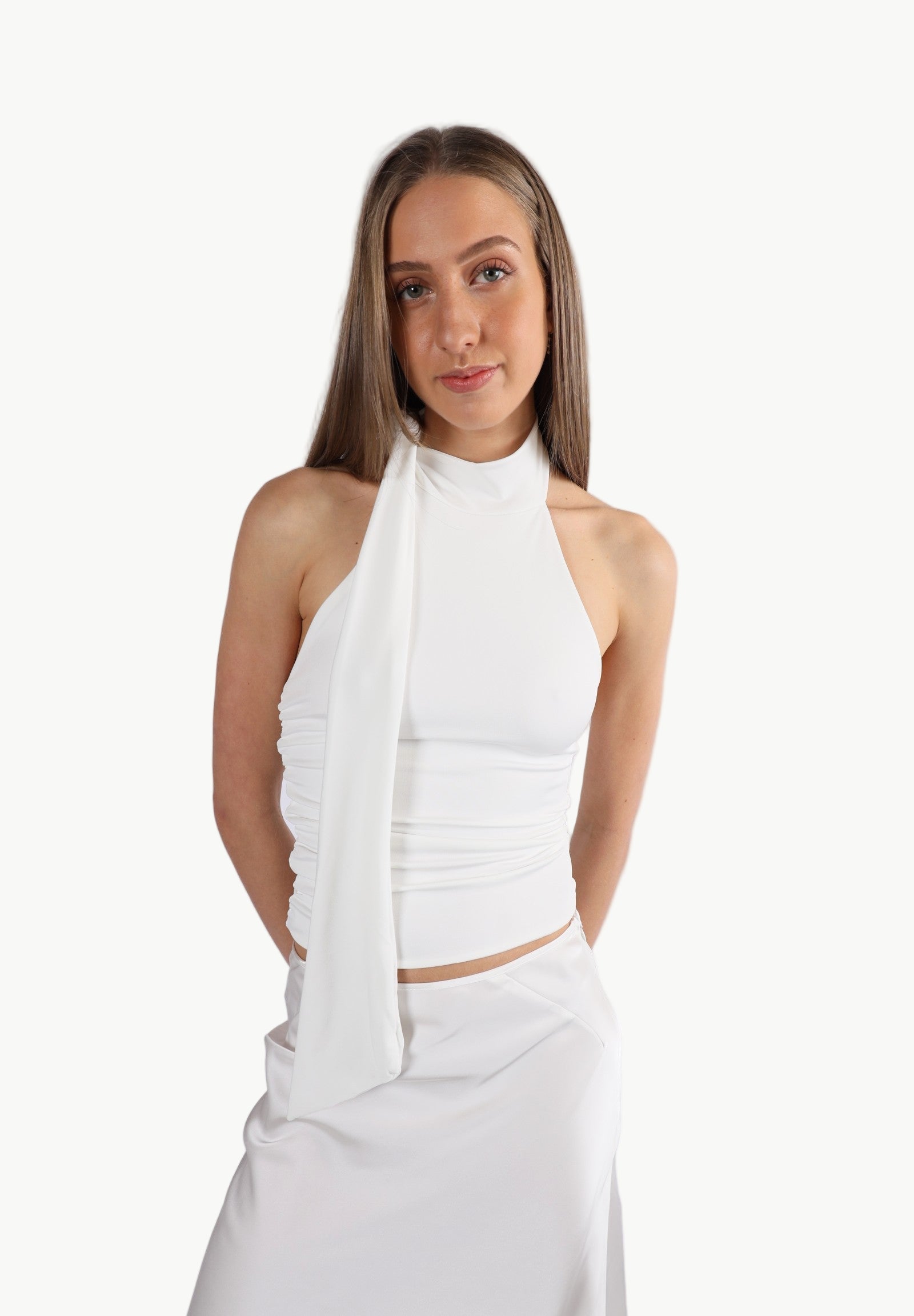 La Libéré Model wearing a white halter top and skirt on a white background